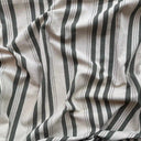 Närbild av Alf i färgen Sage, ett randigt tyg med tidlös design i återvunnen bomull och polyester, perfekt för hållbar och stilren inredning.