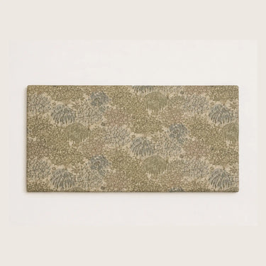 Aran väggmonterad sänggavel med botaniskt mönstrat tyg i beige, gröna och gråblå toner.