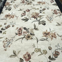 Blommigt tyg på metervara med beige botten och ett elegant blommönster i naturnära färger.