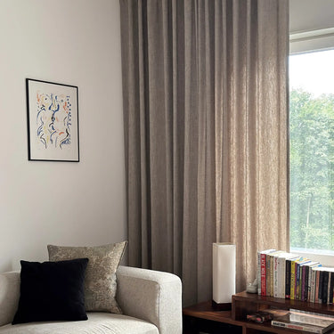 vardagsrum
Måttsydd beige Nova gardin från tak till golv i vardagsrum med trädetaljer och ljus soffa.