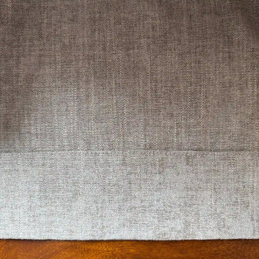 Närbild av beige Nova gardintyg med grå underton, matt yta och tydlig vävd struktur.