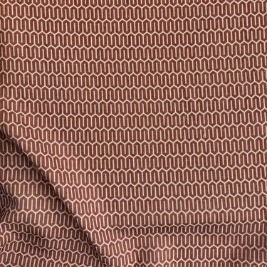 Närbild på skirt gardintyg i rostbrun med geometriskt mönster i polyester