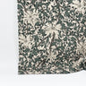 Mönstrat bomullstyg Siv med blommor och slingrande blad i gröna och beige toner, fotograferat med måttband för att visa mönsterskala