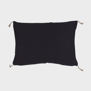 Rektangulärt svart kuddfodral i bomull med ljusa dekorativa tofsar i hörnen, storlek 40x60 cm.