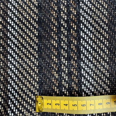 Närbild på vävstrukturen i möbeltyget Stig med måttband som visar mönstrets storlek.