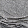 Närbild på möbeltyget Alex i 100 % polyester med diskret vävd struktur i beigegrå toner, visat med mjukt fall som framhäver tygets naturliga känsla och slitstyrka.