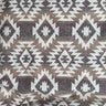 Aspen tyg med geometriskt mönster i beige, brunt och naturvitt, perfekt för plädar, prydnadskuddar och rustik inredning.