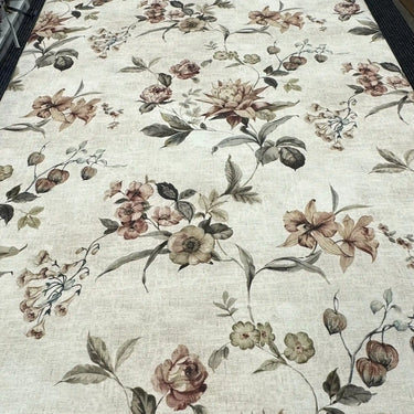 Blommigt tyg på metervara med beige botten och ett elegant blommönster i naturnära färger.