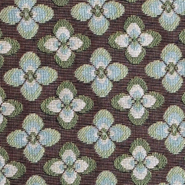Detaljbild av Dalia möbeltyg med retroinspirerat blommönster i grönt, creme och brunt