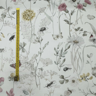 Botaniskt tyg med blommor och insekter, närbild med måttband som visar mönstrets storlek