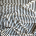 Draperat randigt bomullstyg som visar mjukt fall i naturbeige