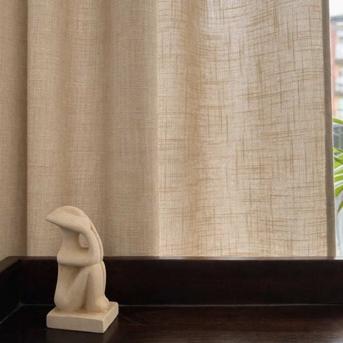 Beige gardintyg i linnelook med struktur, släpper igenom ljus och skapar en varm känsla
