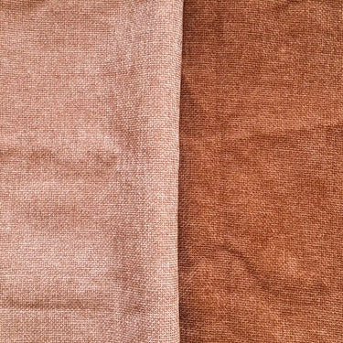 Närbild av Milena möbeltyg i puderrosa och terrakotta med strukturvävd yta