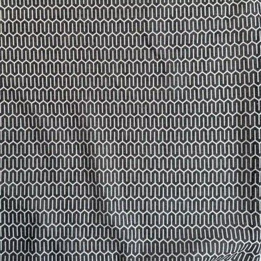Närbild på mörkgrått skirt gardintyg med geometriskt mönster