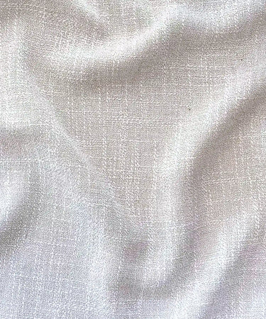 Närbild på Sophia gardintyg i 100 % polyester med mjuk struktur, vackert fall och ljusbeige ton.
